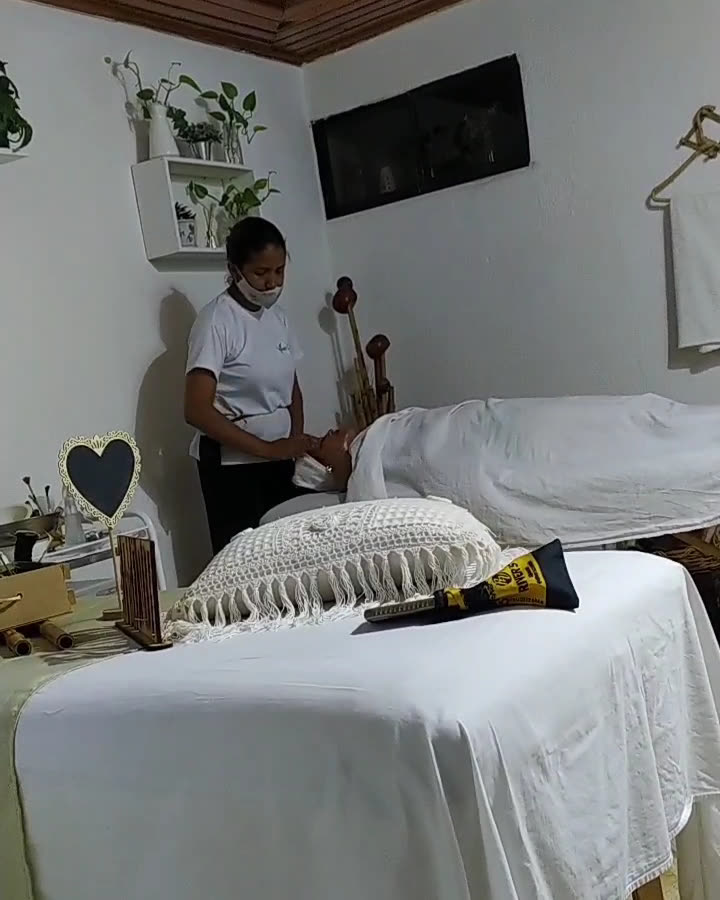 Terapeuta preparando a una clienta en la cabina, con las cañas de bambú al fondo