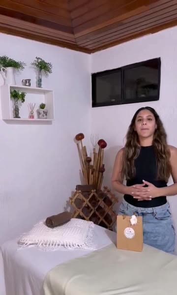 Cabina iluminada con camilla, matas en repisas y cañas de bambú