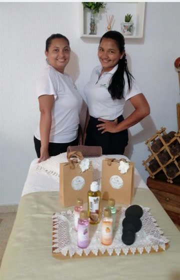 Equipo de Organic Spa con bolsas de regalo y aceites sobre la camilla