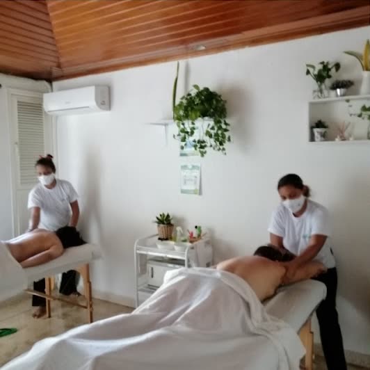 Dos terapeutas dando masaje en la cabina de techo de madera