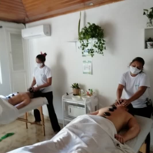 Masaje con piedras en la cabina, con matas en las repisas